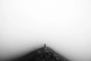 Brouillard dense en montagne : randonneur isolé sur arête, repères absents - désorientation et importance de la sécurité en montagne.