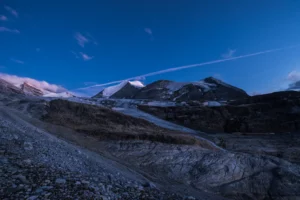 Paysage de montagne et glacier photographié à l’heure bleue, avec une lumière froide et un ciel profond.