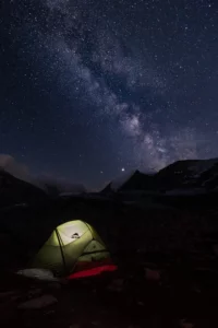 Astrophotographie de la voie lactée au-dessus d’un paysage nocturne en montagne, étoiles nettes en pose longue.