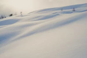 Congères et ombres douces sur une pente enneigée, photo minimaliste d’hiver
